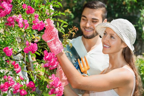 Gardener trimming an overgrown hedge in Friern Barnet
